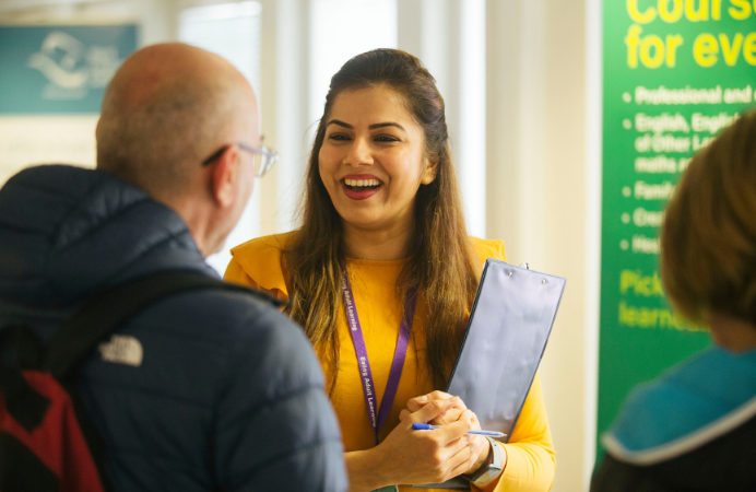 A woman speaking with a man at a jobs fair