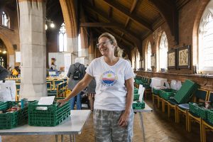 Woman standing next to food basket in a church hall