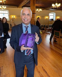 Harsev Bains of the Southall Community Alliance holding a crystal award