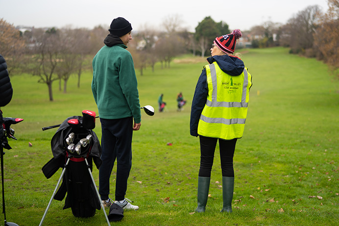 Teenager and a coach on a golf course