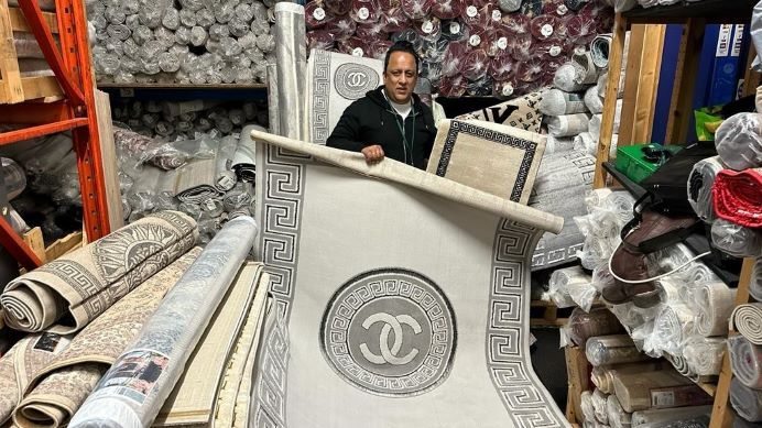 Trading standards officer surrounded by fake branded carpets