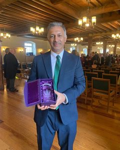 Janpal Basran of the Southall Community Alliance holding a crystal award