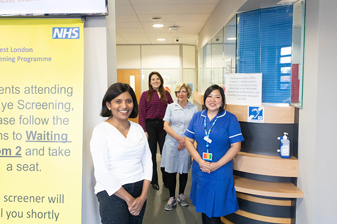 A group of four female GPs and nurses at a GP surgery, standing together