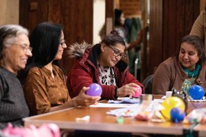 Four women enjoying arts and crafts around a table