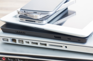 Digital devices in a pile including laptops and mobile phones