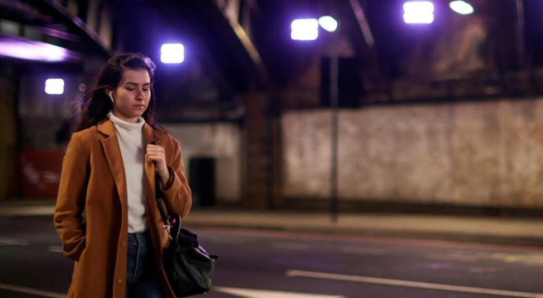 Girl walking in a darkly lit suburban area