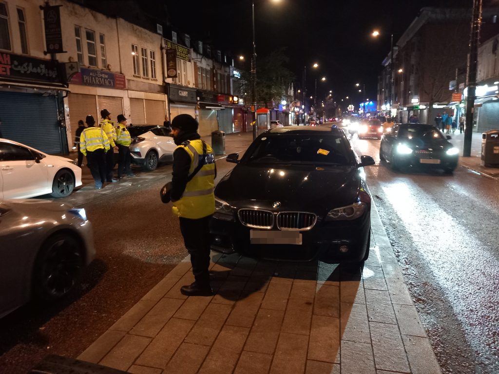 Two cars parked in Southall with an enforcement officer in front
