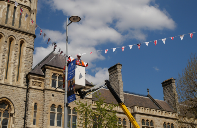 Cllr Peter Mason on a cherry picker placing bunting in front of Ealing Town Hall