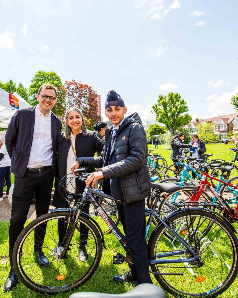 Councillors Peter Mason and Jasbir Anand with a school boy who has been given a free bike