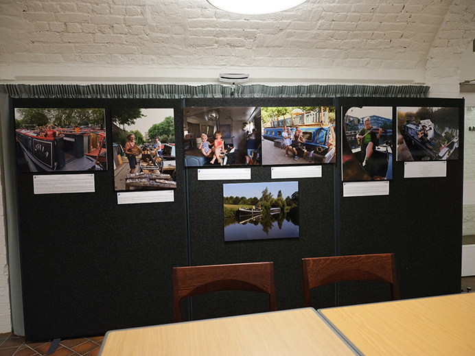 A board at an art exhibition with a row of photographs on it