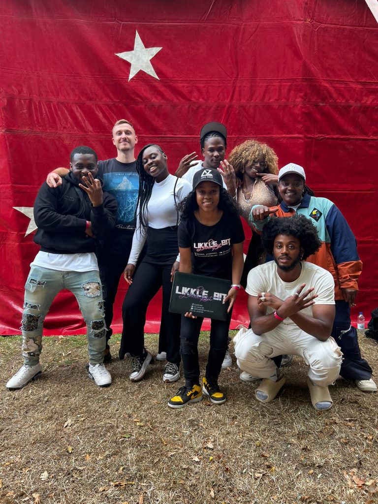 A group of young girls and boys posing in front of a red flag.