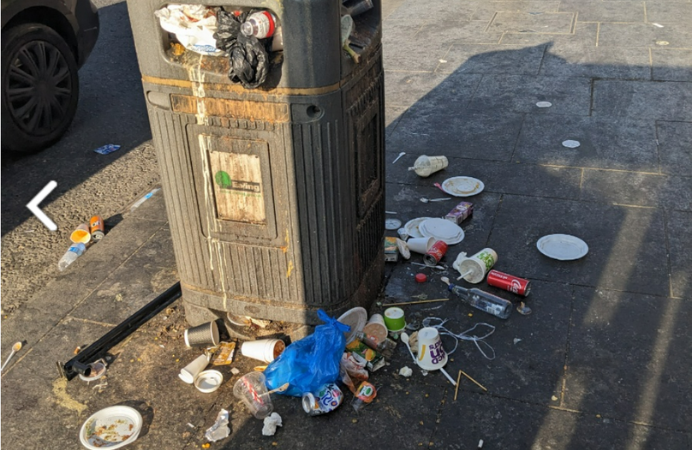 Bin with council's logo overflown with rubbish.