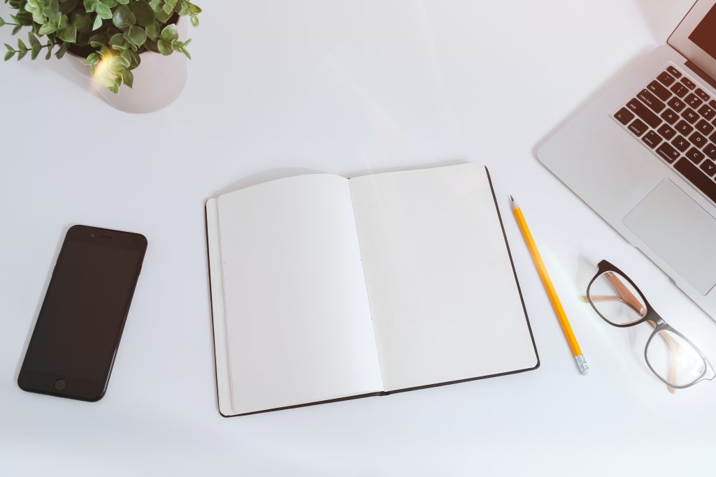 notepad and pencil, glasses and computer