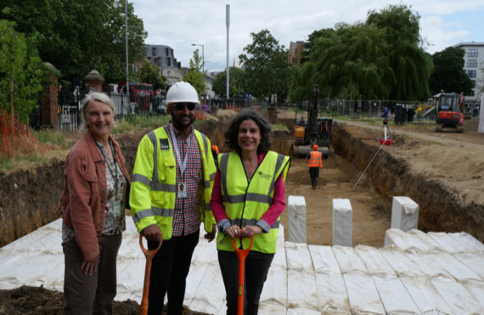 Cllr Costigan with a spade and two council colleagues in front of the sustainable drainage system at Dean Gardens