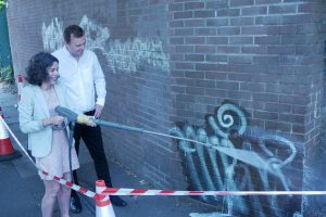 Cllr Mason and Cllr Costigan remove graffiti from wall