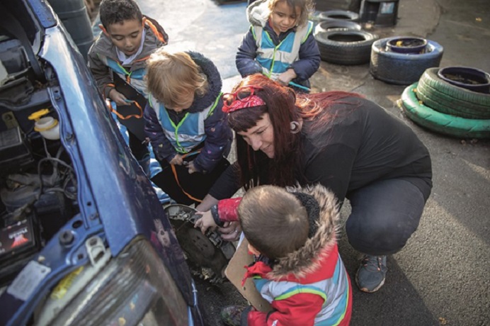 Teacher with small children besides a car