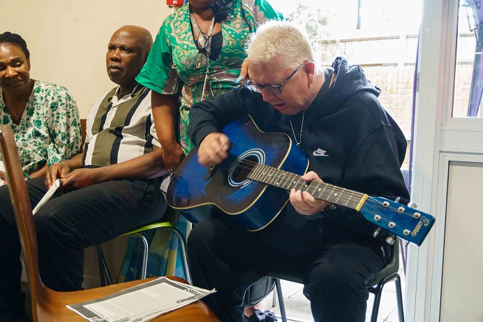 older man playing a guitar