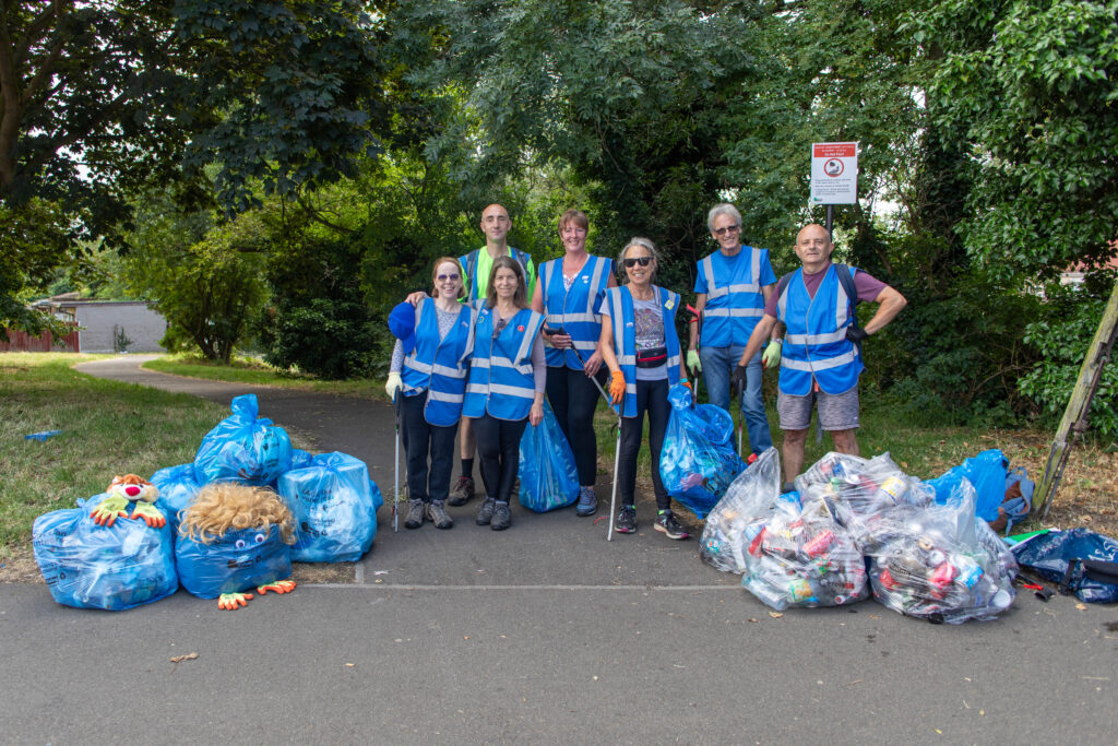 LAGER Can volunteers standing outside with bags of litter, holding their litter pickers