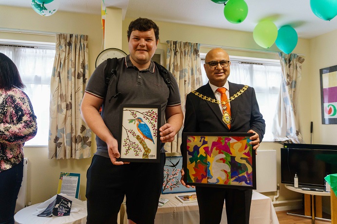 Two men holding art work - with one being the Mayor of Ealing