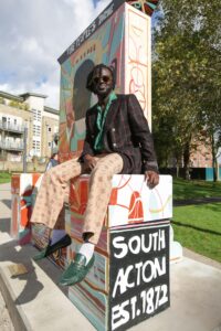 Adébayo Bolaji, a London artist sitting on a sculpture he designed