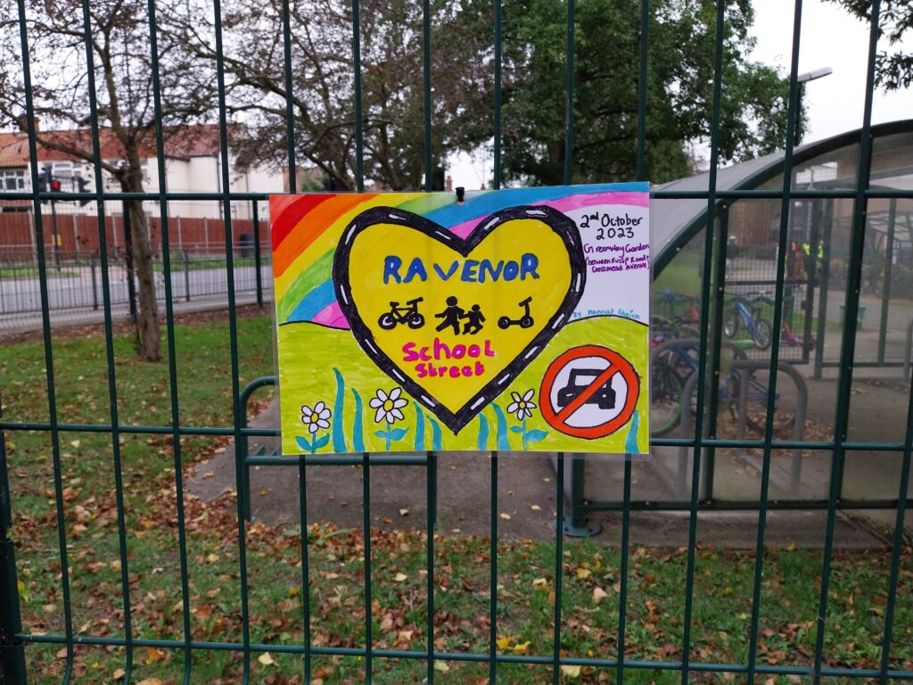 Children's painting saying Ravenor school street at the railings of the school
