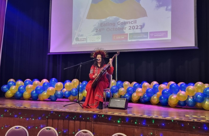 A performer on stage plays traditional Ukrainian instrument