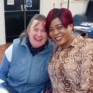 BEfriend volunteer and client. a black and a white woman sitting together with big smiles