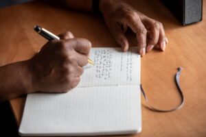 close up of hands writing in a notebook
