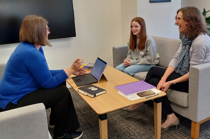 Young girl and two women sitting talking and laughing