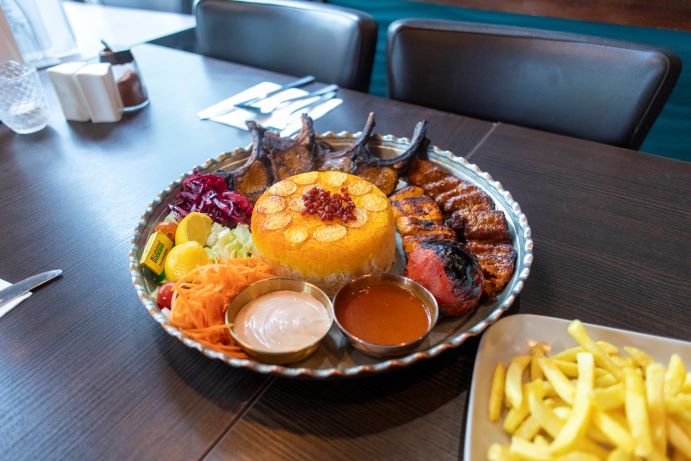 platter of food with rice, chops, dips, salad on the restaurant table