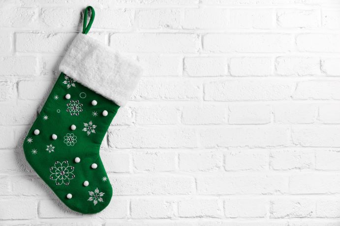 green Christmas stocking hanging on a white brick wall