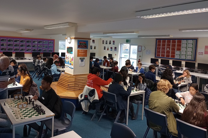 School room with many school age children competing in a chess tournament