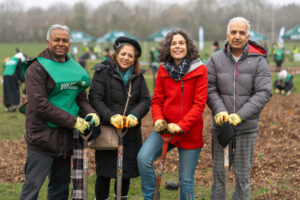 Councillor Costigan planting trees with others on 2 December 2023.