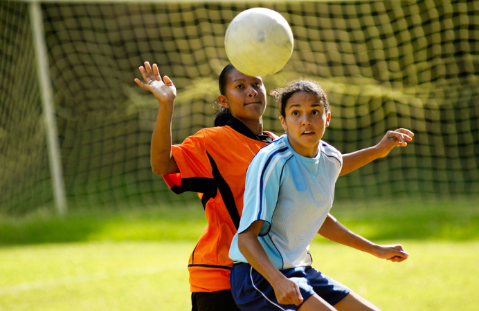 Two girls playing football