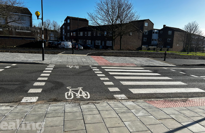 A strip of improved road and pavement in Northolt with a bicycle painted on the road