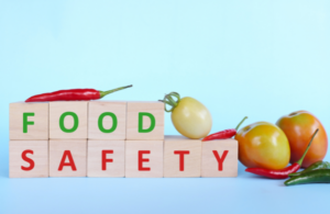 Food safety written on blocks with fruit next to ir