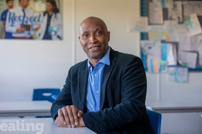 black man sitting at a desk in a classroom