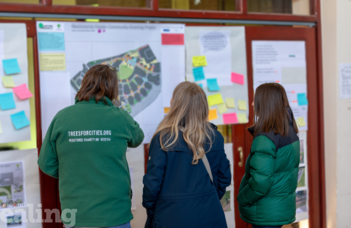 Three women with their backs looking at information boards