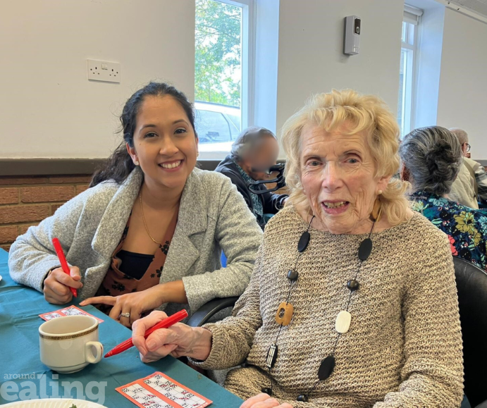 a young lady sitting next to an old lady at Bingo