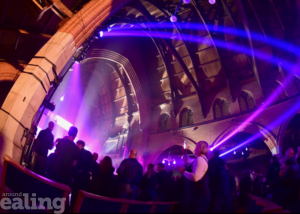 Multiple different colour light displays inside a church, with live music and an audience