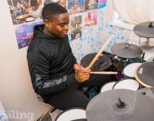 boy playing drums in his bedroom