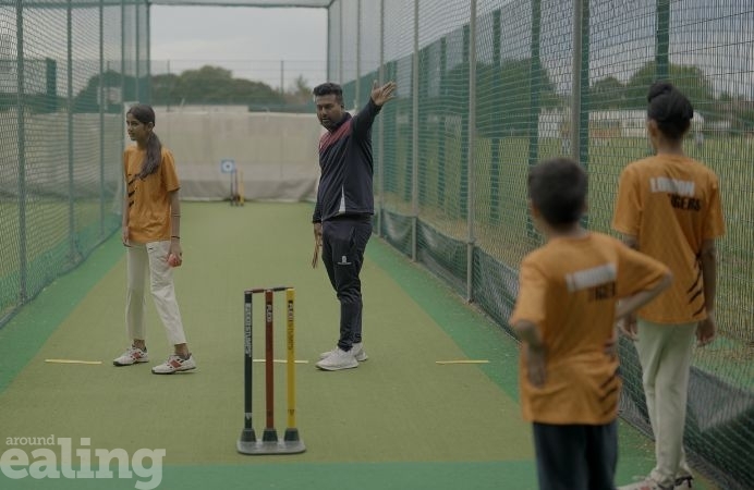 Tanvir, Mr Tiger, coaches young boys and a girl in cricket nets at Tiger Cricket Club