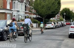 cyclists go down car lined street