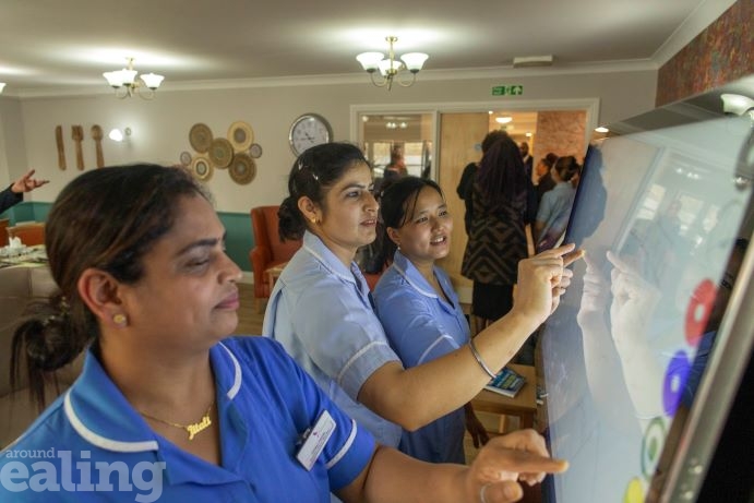 Care workers looking at interactive boards
