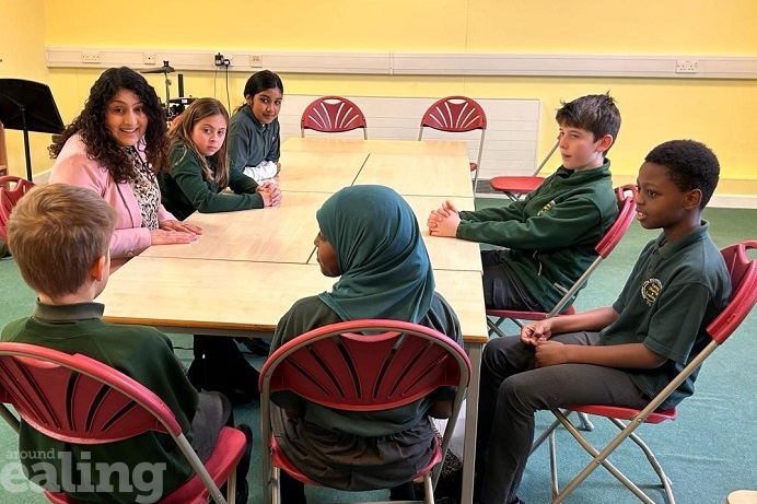 Cllr Kamaljit Nagpal at a table with 6 pupils from Hobbayne Primary School