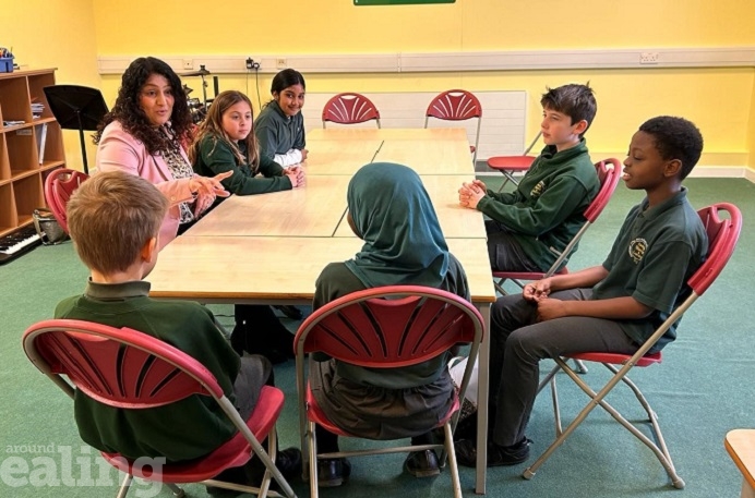 Cllr Kamaljit Nagpal at a table with 6 pupils from Hobbayne Primary School