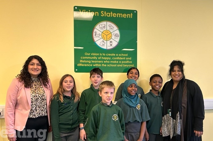 Cllr Kamaljit Nagpal with 6 pupils from Hobbayne Primary School and the headteacher in front of a cream coloured wall