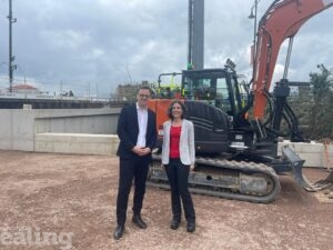 Cllrs Mason and Costigan stand in front of machinery on site of new cycling plans