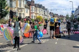 Children playing with toys in the middle of the road.