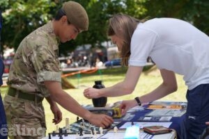 armed forces cadet playing chess with woman